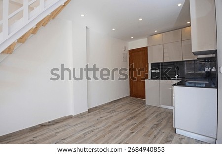 Modern open plan corner kitchen in an unfurnished apartment residence with black marble worktop