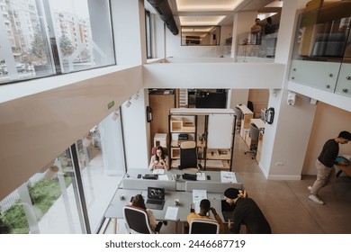 Modern open-plan office environment capturing employees at their desks, collaboration in progress, and incidental interactions.