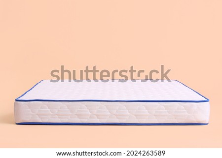 Modern orthopedic mattress on color background
