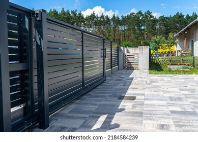 Modern panel fencing in anthracite color, visible sliding gate to the garage as well as a handle and a lock. - Shutterstock ID 2184584239