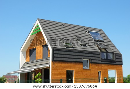 Modern Passive House Exterior. Modern energy efficiency house with skylight windows and solar panels on the roof top.