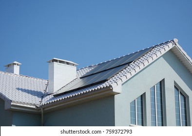 Modern passive house with solar panels and white roof for energy efficiency. - Shutterstock ID 759372793