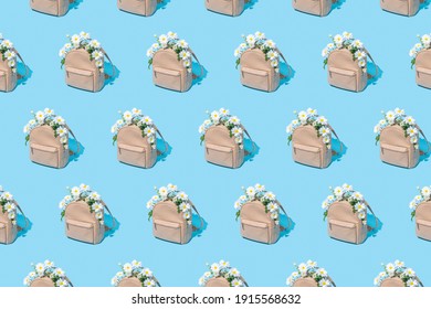 Modern Pattern Made Of School Bag Full Of White Daisy Flowers On Pastel Blue Background. Back To School, Trendy Spring Semester Concept.