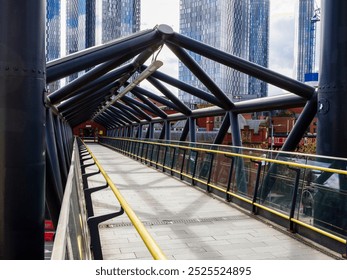 Modern pedestrian bridge with geometric steel beams in an urban cityscape. Deansgate train station Manchester UK. - Powered by Shutterstock