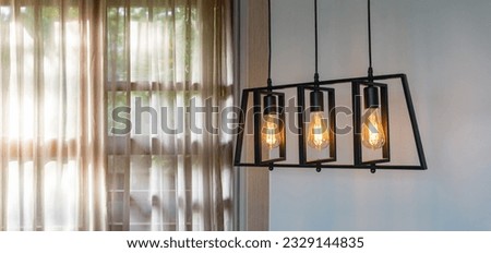 Modern pendant lights with vintage lights bulb hanging in the living room. Panorama view. White curtain interior decoration design in the living room with sunlight background.