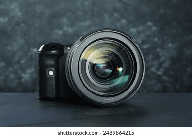 Modern photo camera on black table. Photographer's equipment