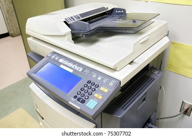 Modern Photocopier With Digital Display Plugged To The Wall In The Office Supply Room.