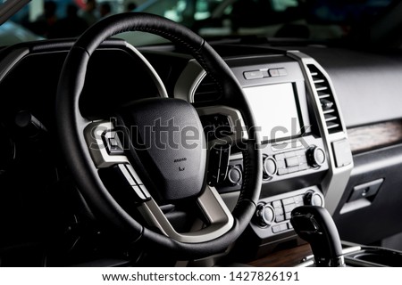 Modern pickup truck interior, touch screen panel, leather seats and automatic transmission lever - dark light