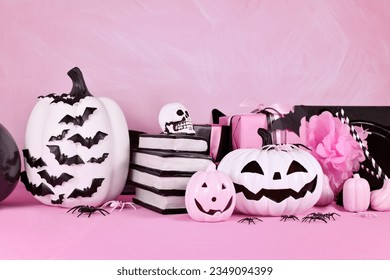 Modern pink Halloween decor with black and white pumpkins, spell books and spiders with copy space - Powered by Shutterstock