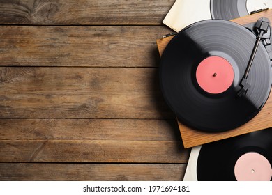 Modern player and vinyl records on wooden background, flat lay. Space for text - Shutterstock ID 1971694181