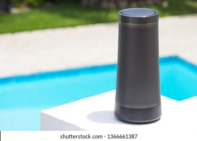 Modern Portable Music Speaker With Voice Assistant Near The Swimming Pool.