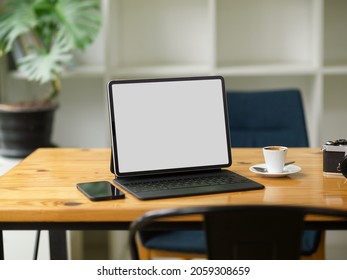 Modern Portable Tablet Computer With Magic Keyboard In Blank Screen Mockup Stand On Wooden Table In Coffee Shop