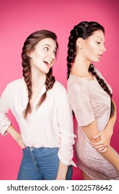 Modern portrait of two pretty girls with two pigtails . Fashionable image, the model with braids.