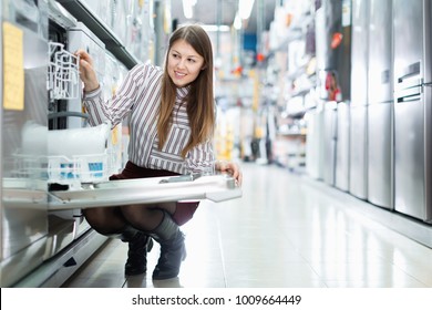 Modern  Positive Female Housewife Buying Dishwasher In Domestic Appliances Section