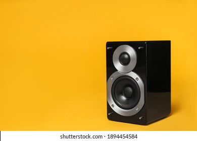 Modern powerful audio speaker on yellow background, space for text
