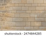 Modern Precise Jointed Sandstone Blocks and Mortar Wall. Close-up building exterior stonework. Ideal Graphic Design Background Backdrop or Architectural Texture.