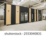 Modern prefabricated tiny house being built inside a spacious factory, showcasing innovative construction techniques and sustainable housing solutions