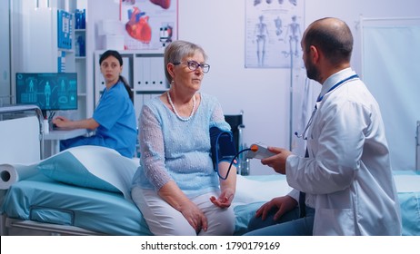 In modern private hospital or clinic nurse writes blood pressure levels while doctor dictates them. Healthcare medical medicinal system, disease prevention treatment, illness diagnosis