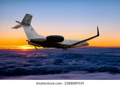Modern private jet flying in the sunrise sky