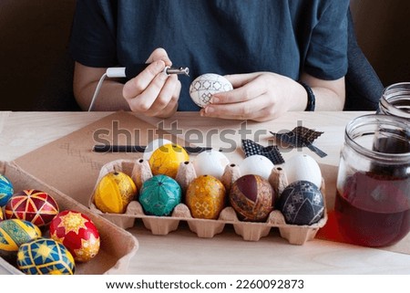 the modern process of making Easter eggs in traditional wax technology, the hands of a woman at work