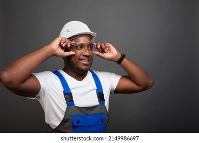 A modern professional architect carefully adjusts his goggles while on a construction site. A young foreman tries on new glasses to comply with safety precautions at the construction site