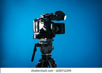 Modern Professional Video Camera On Blue Background