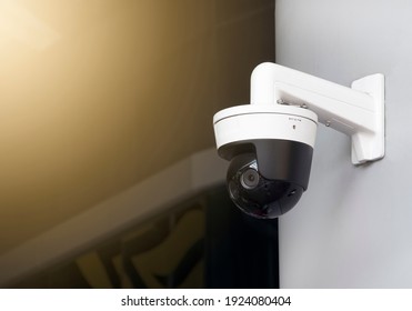 Modern public CCTV camera on wall with blur building background. Recording cameras for monitoring all day and night. Concept of surveillance and monitoring with copy space.