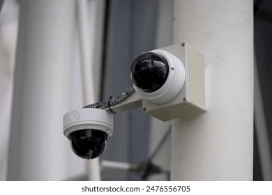 Modern public CCTV camera on the wall. cameras record for monitoring activities throughout the day and night. Supervision and monitoring concept.