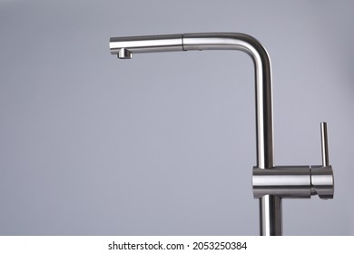 Modern Pull Out Kitchen Faucet On Grey Background. Space For Text