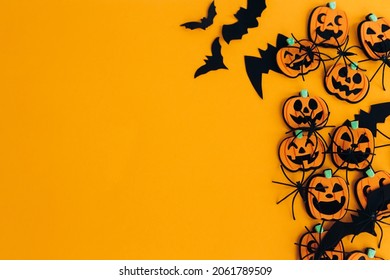 Modern Pumpkins Jack O Lantern, Spiders, Bats Border Flat Lay On Orange Background With Space For Text. Season's Greeting Card. Happy Halloween. Halloween Decorations On Yellow Paper