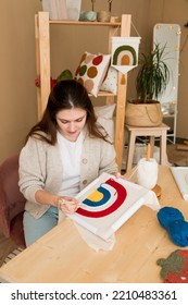 Modern punch needle kit for beginners. Young woman embroidering handmade picture rainbow on canvas in workshop. Handicraft, hobby, diy for decoration home concept - Shutterstock ID 2210483361
