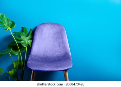 Modern Purple Very Peri Velour Chair on wooden legs, blue background