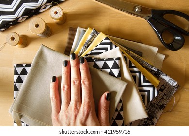 Modern Quilt Fabrics With Sewing Spools, Scissors And Woman Hand On The Wood Table