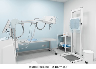 Modern radiology room with fluorography scanning equipment and empty bed for X-ray diagnostic and healthcare exam of patients in hospital. Roentgenography medicine and health concept. - Powered by Shutterstock