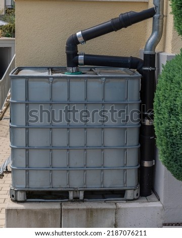 Modern rainwater cistern at the side of a house collecting water for environmental conservation. Conserving water reduces wear and tear on major resources such as water and wastewater treatment plants