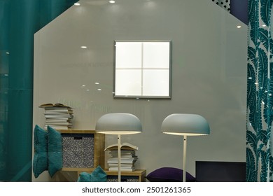 Modern reading nook with white lamps, stacked books, and decorative pillows. Interior design mockup with a lit wall panel and teal accents. Studio shot. - Powered by Shutterstock