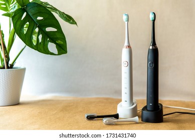 Modern rechargeable sonic or electric toothbrush set with charger in bathroom. Concept of professional oral care and healthy teeth by using ultrasonic smart toothbrush. Minimal design