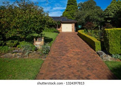 Modern Red Brick House With A Long Driveway And A Beautiful Garden. Suburban Building In The Blue Mountains Of Australia.