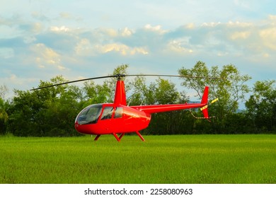 Modern red helicopter on green grass outdoors - Shutterstock ID 2258080963