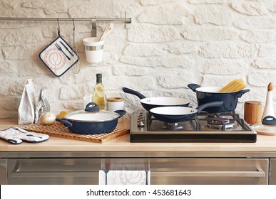 Modern Red Kitchen Behind Brick Wall With Red Cookware Set