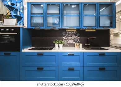 Modern Red Kitchen Interior With Black Brick Walls, Wooden Countertops With A Built In Sink And A Cooker.  Color Of The Year 2020 Pantone Classic Blue