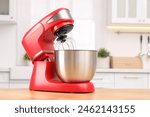 Modern red stand mixer on wooden table in kitchen, space for text