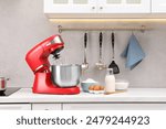 Modern red stand mixer and products on white countertop in kitchen