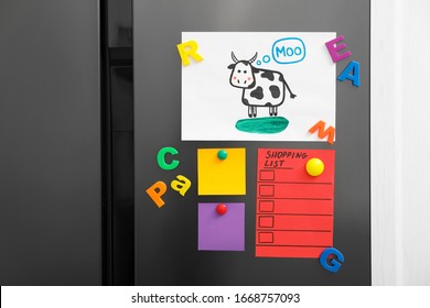 Modern refrigerator and child's drawing  notes   magnets  closeup