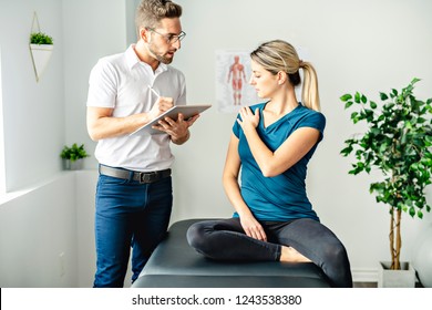 A Modern Rehabilitation Physiotherapy Man At Work With Woman Client Talk About Shoulder Problem