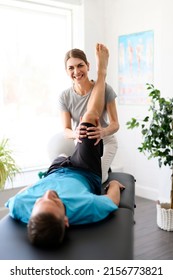 A Modern Rehabilitation Physiotherapy Woman Worker With Man Client Leg Treatment