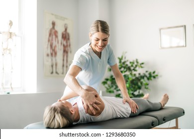 A Modern rehabilitation physiotherapy worker with woman client - Powered by Shutterstock