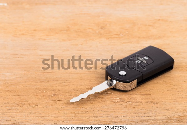 Modern remote car key\
on wooden background