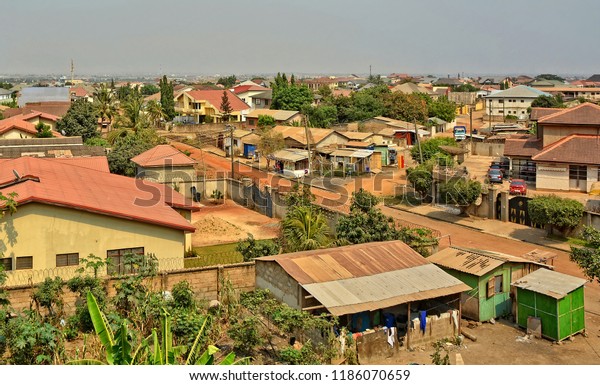 Modern\
residential buildings in Africa. Suburb lifestyle in developing\
countries. Beautiful urban landscape. Top view. Wonderful houses\
with red tile roofs, yards, fences, roads, cars\
