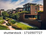 Modern residential buildings in the public green area. Apartment houses in Europe. Beautiful view of real estate homes in Milan, Italy. Business district in summer. Walking area with trees and grass.